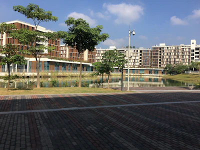 A panoramic view of a recently completed residential complex with landscaped gardens and modern architecture under a clear blue sky.