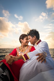 woman and man sitting together near sea