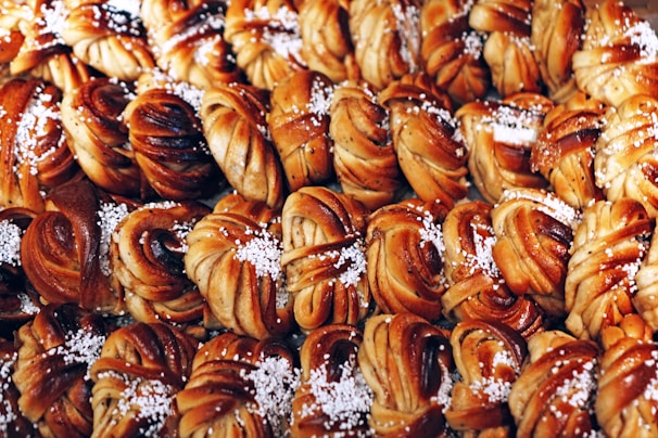 Photo of freshly baked filled brioches lined up on a factory conveyor belt.