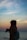 woman holding DSLR camera near body of water