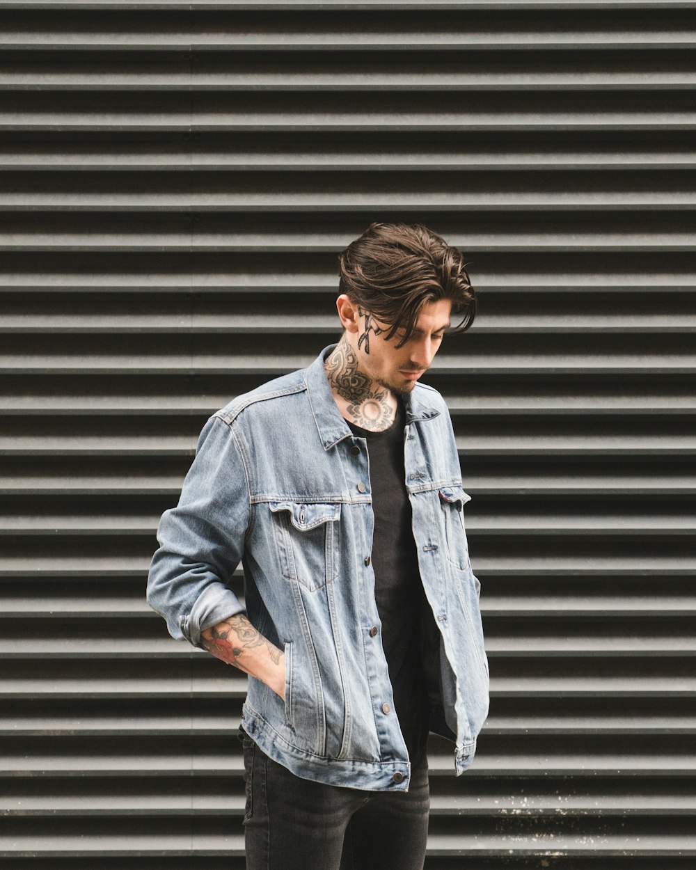 man standing in front of roll-up door at daytime