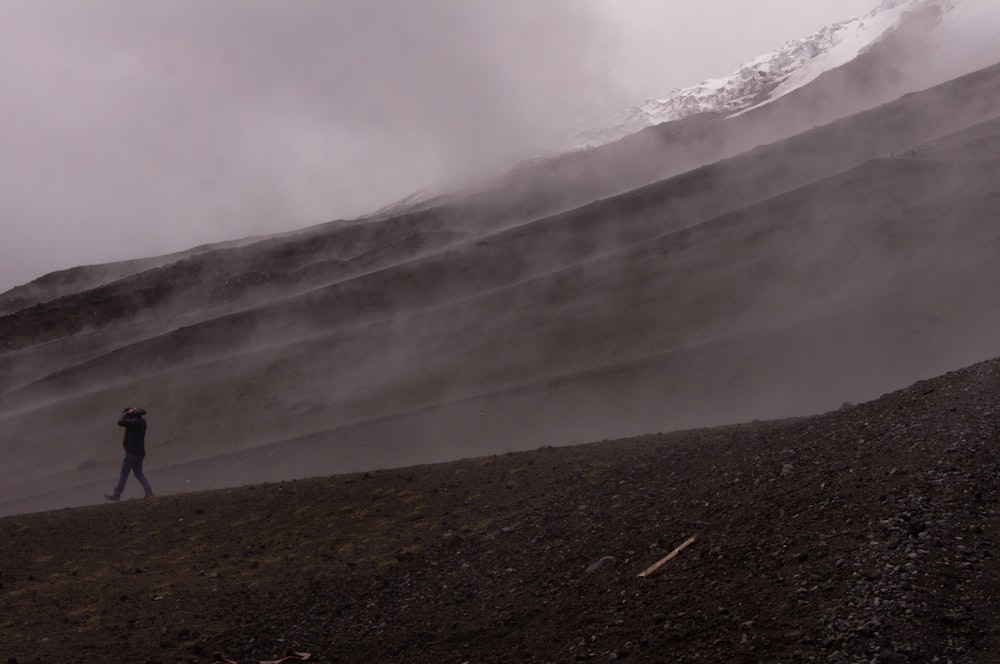 person walking on gravel with grey smoke