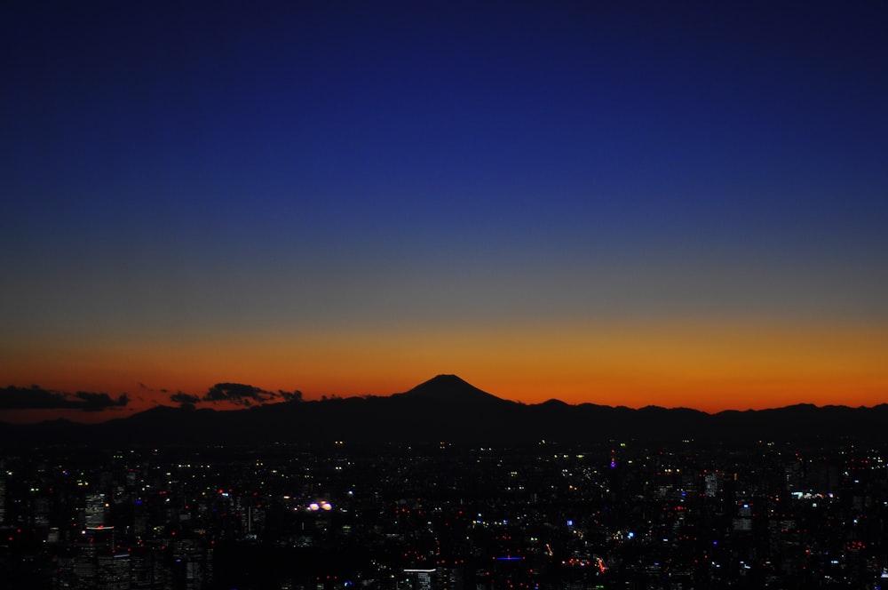 city near mountain during blue hour aerial photography