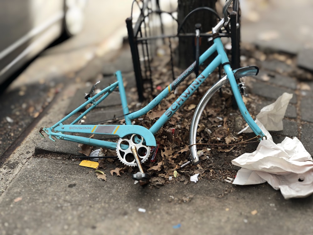 Cuadro de bicicleta Schwinn azul apoyado en un cuadro de metal negro