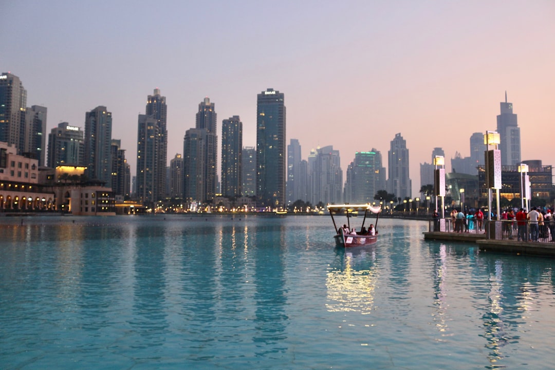 body of water with high-rise building in distance, Outside the Dubai Mall after going up the Burj Khalifa.