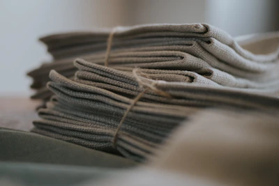 Handwoven cotton satin unstitched suit set folded neatly with visible texture and earthy tones.