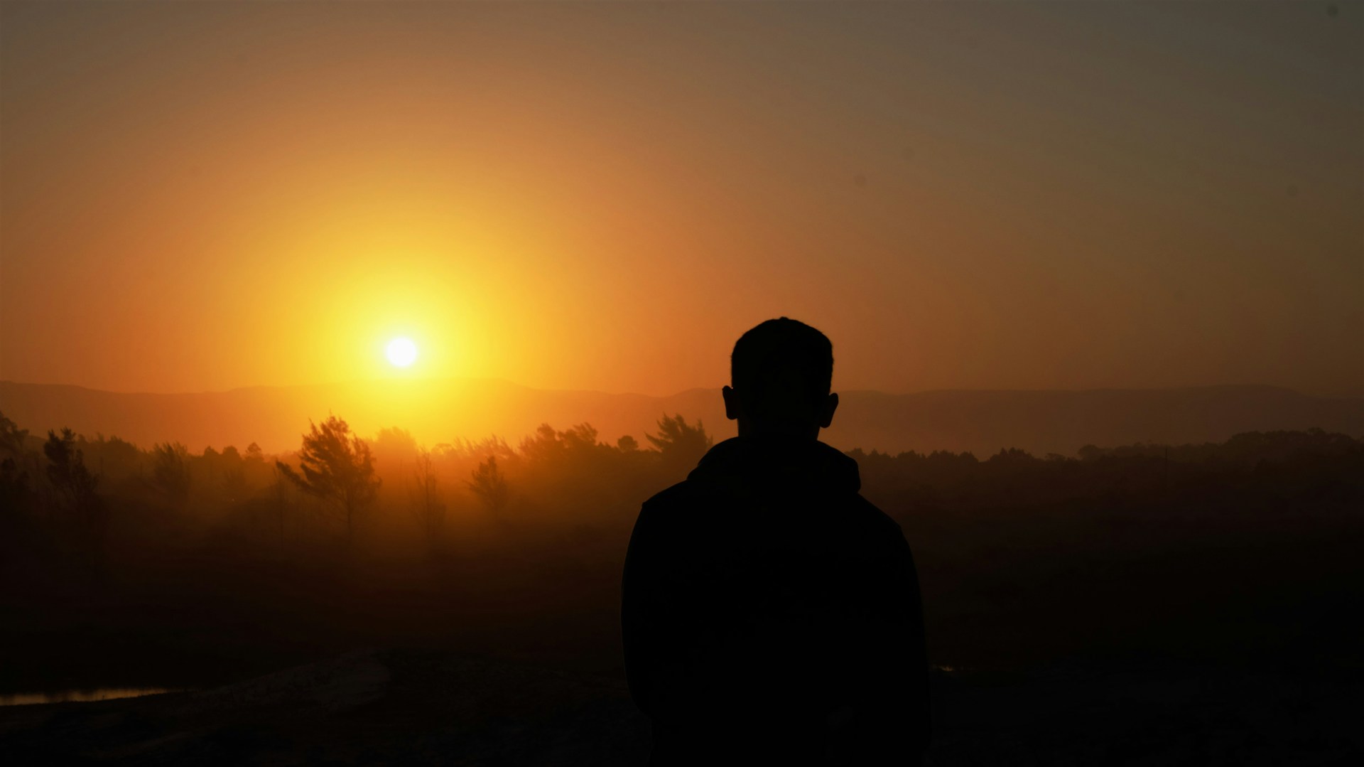 A silhouette of a man against a sunset backdrop, the golden light creating a timeless, emotional atmosphere.