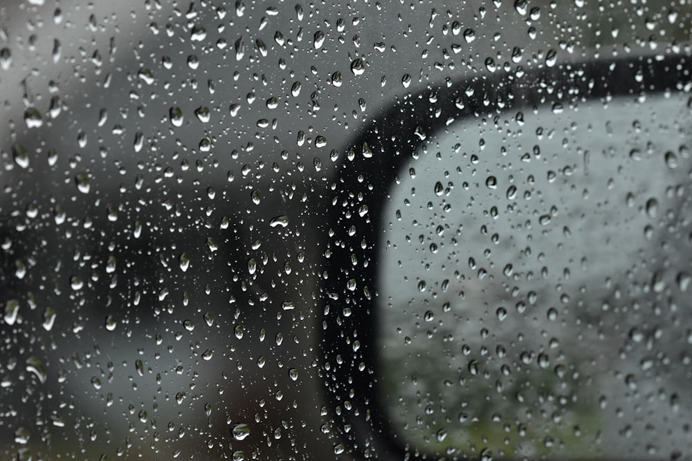 Espejo retrovisor lateral de un automóvil con gotas de lluvia