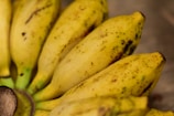 Fresh ripe bananas and ingredients laid out on a wooden table ready for baking.