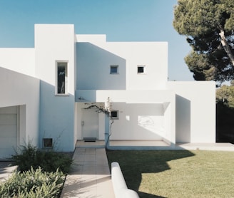 white concrete house near green tree during daytime