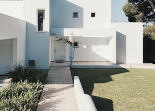 white concrete house near green tree during daytime