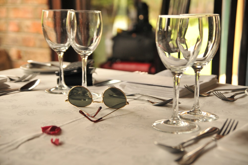 selective focus photography of clear long-stem wine glasses on table