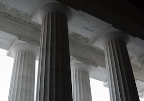 Elegant cantera stone columns supporting a traditional-style porch roof.