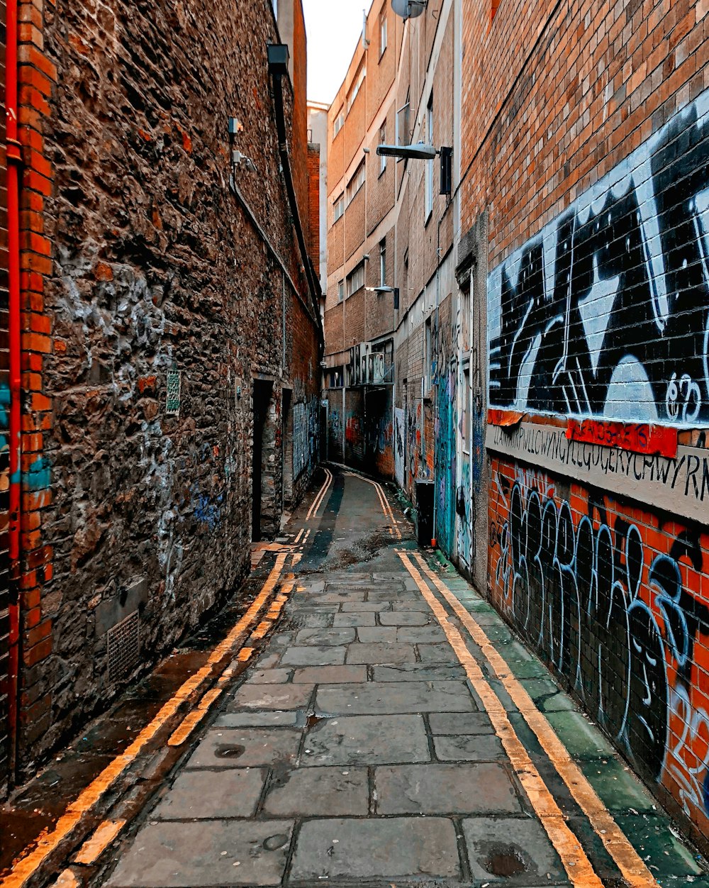 gray paveway between brown brick walls