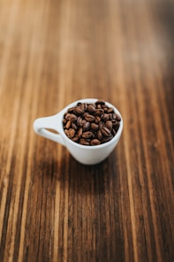 round white ceramic mug with coffee beans