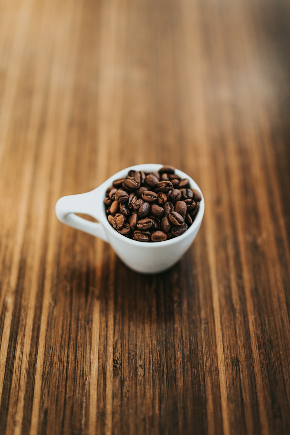 コーヒー豆と丸い白いセラミックマグカップ