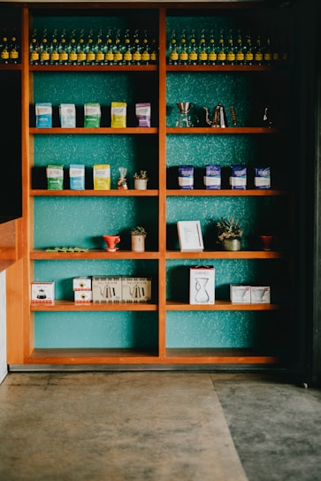 Photo of colorful church merchandise including t-shirts, mugs, and books displayed on wooden shelves