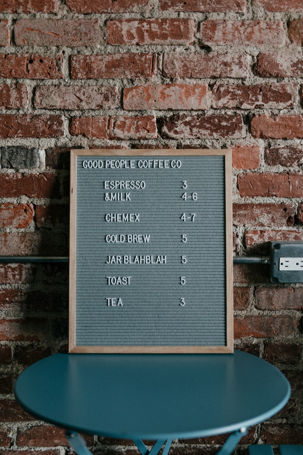 good people coffee co menu board on top of blue table