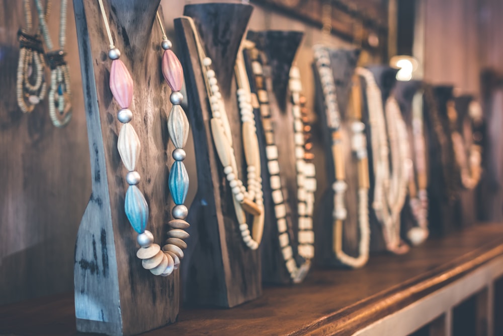 assorted-color necklace lot on black wooden necklace holders