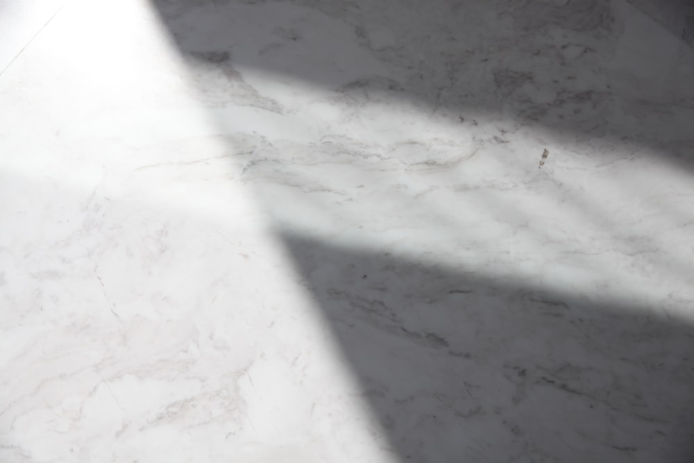 Una encimera de mármol blanco con una larga sombra