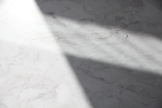 A white marble counter top raking in low light