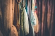 A row of colorful fabrics and textiles hangs closely together, showcasing various textures and patterns. Soft lighting adds a cozy and inviting atmosphere to the scene.