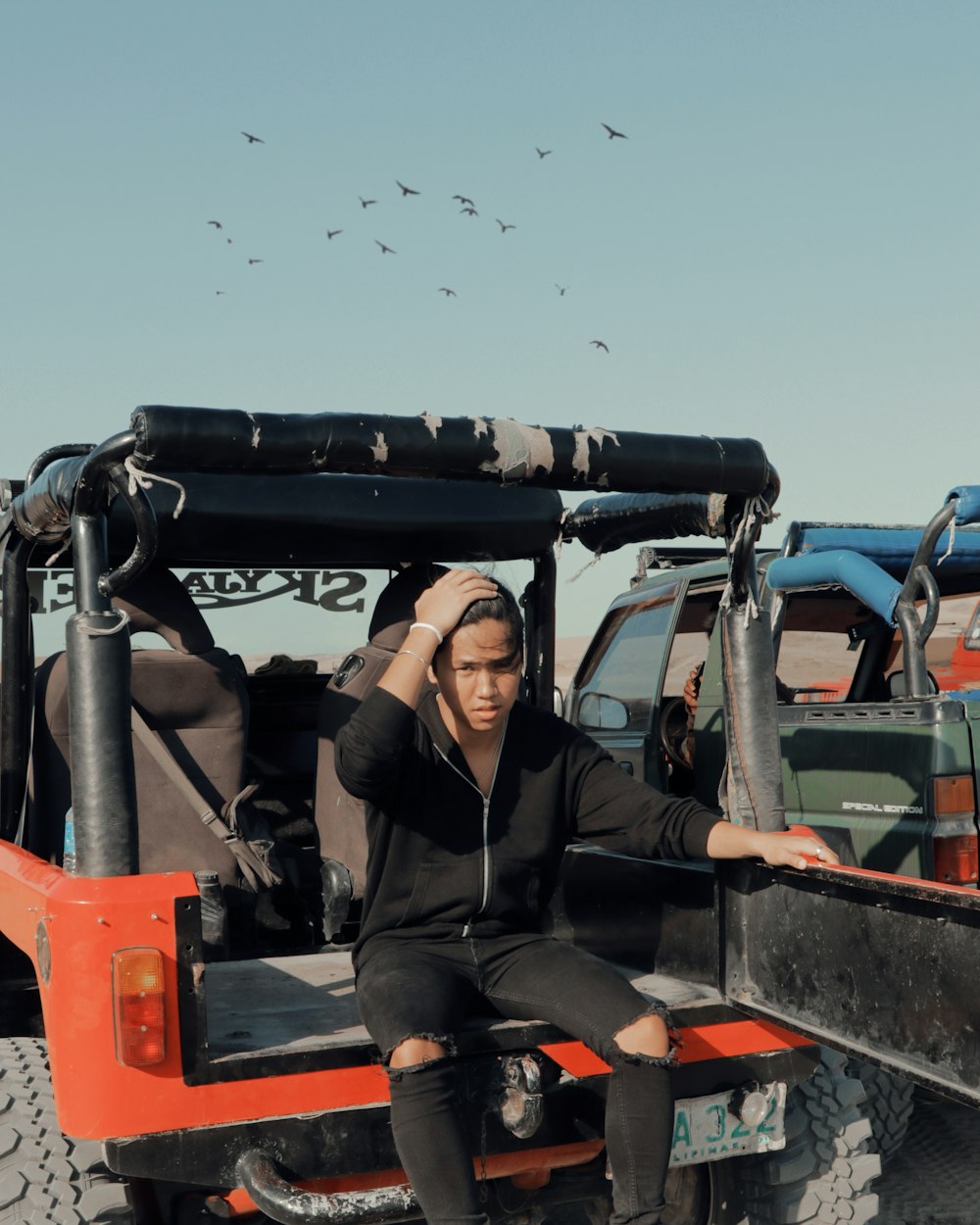 man sitting on back of red vehicle