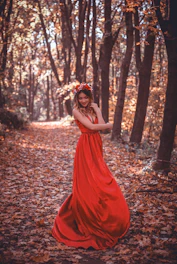 Bohemian-style flowing dress in burnt amber tones displayed against a backdrop of autumn leaves.