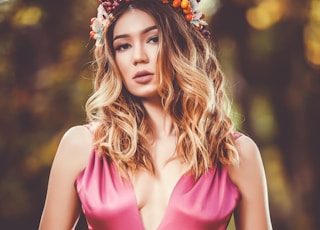 woman in pink V-neck sleeveless dress wearing flower crown in bokeh photography