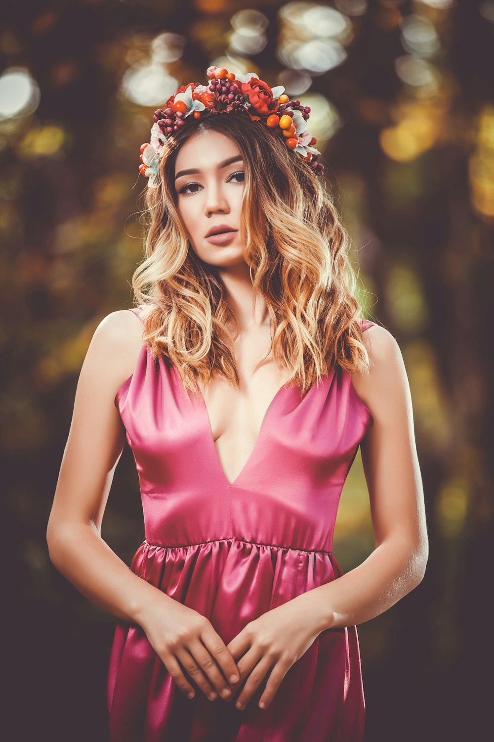 Frau im rosa ärmellosen Kleid mit V-Ausschnitt und Blumenkrone in der Bokeh-Fotografie