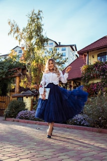 Photo of a plus size woman wearing a flowing skirt and blouse set, walking outdoors with a gentle breeze.