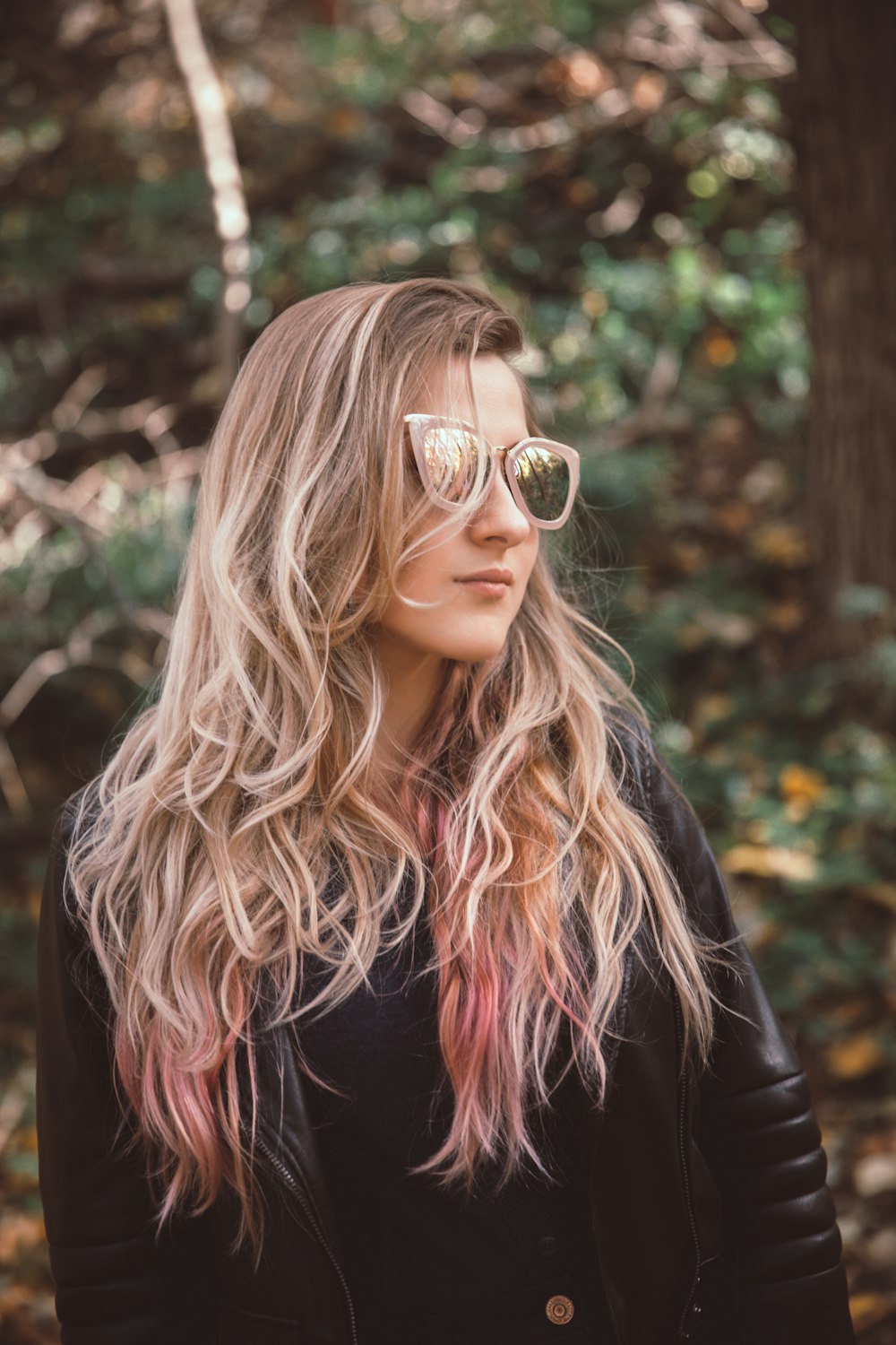 Frau mit Sonnenbrille und Lederjacke mit Blick auf die rechte Seite