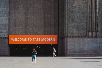 man standing on pavement near building during daytime modern teams background