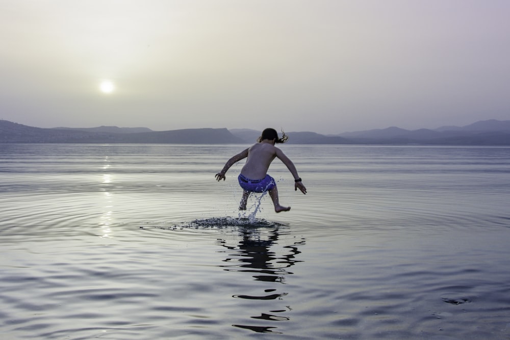 Zeitrafferfotografie eines Mädchens, das auf dem Wasser springt