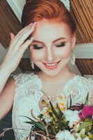 woman wearing bridal gown touching her forehead