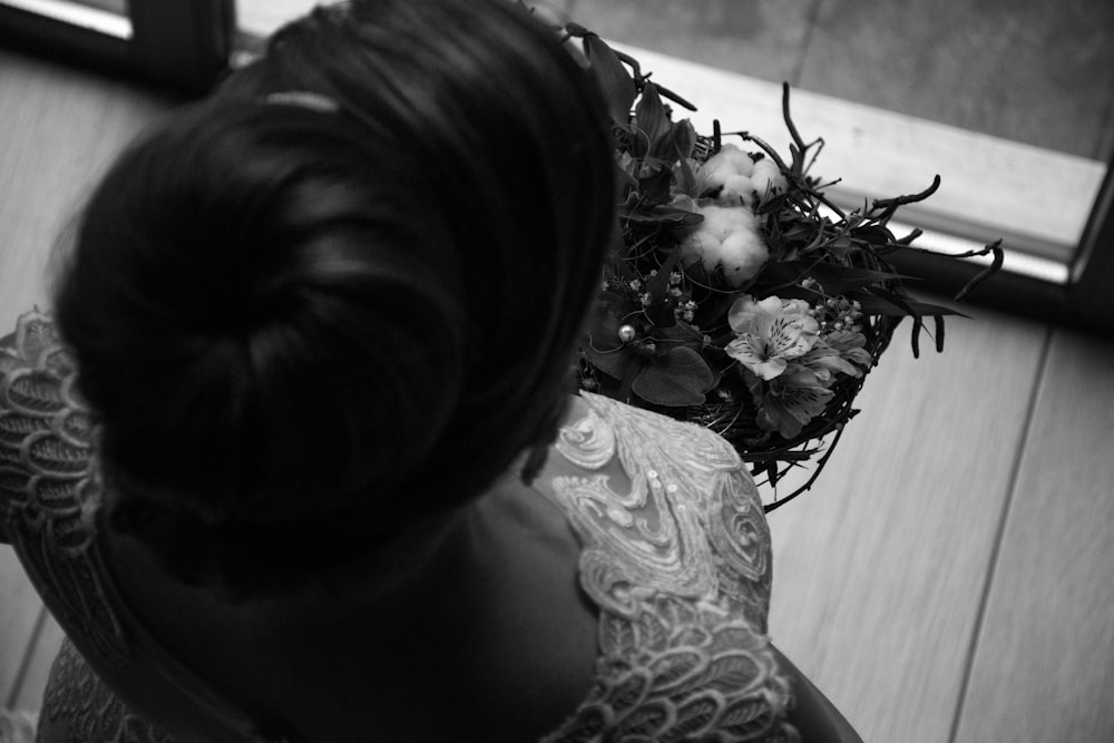 Graustufenfoto einer Frau, die Blumen hält