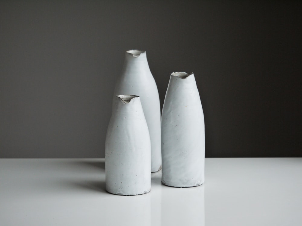 three white vases on table