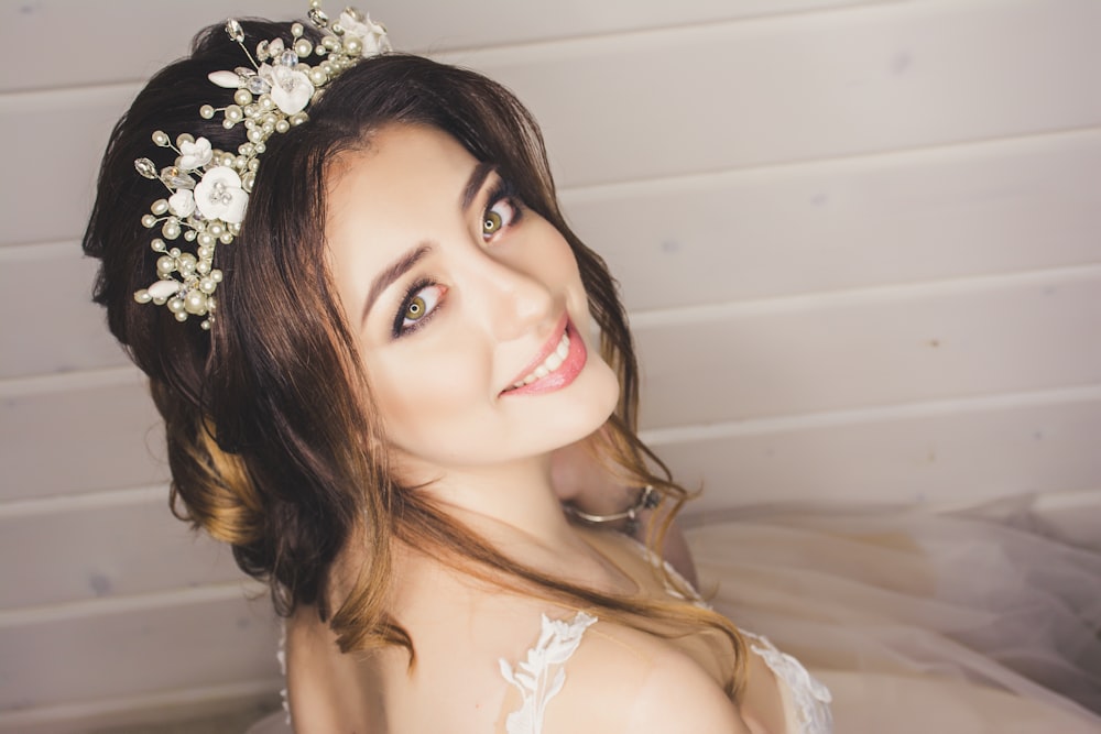 woman with white floral headdress beside white wall