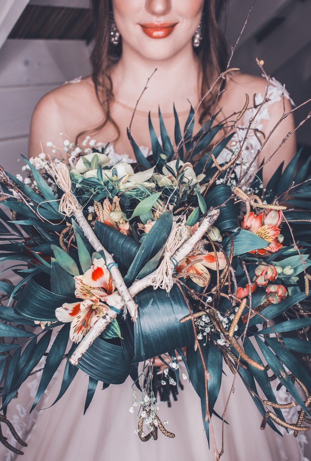 fotografía de enfoque selectivo de mujer sosteniendo ramo de flores