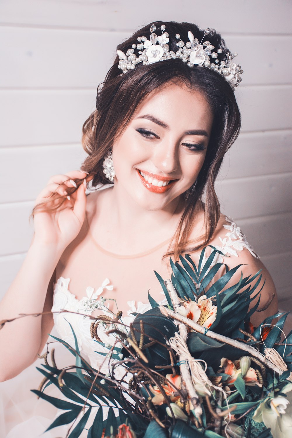 a woman wearing a tiara holding a bouquet of flowers