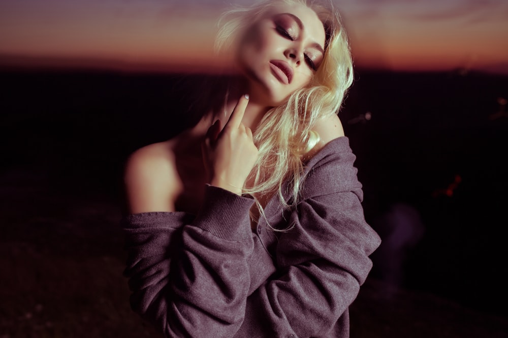 woman holding her neck inside dark room