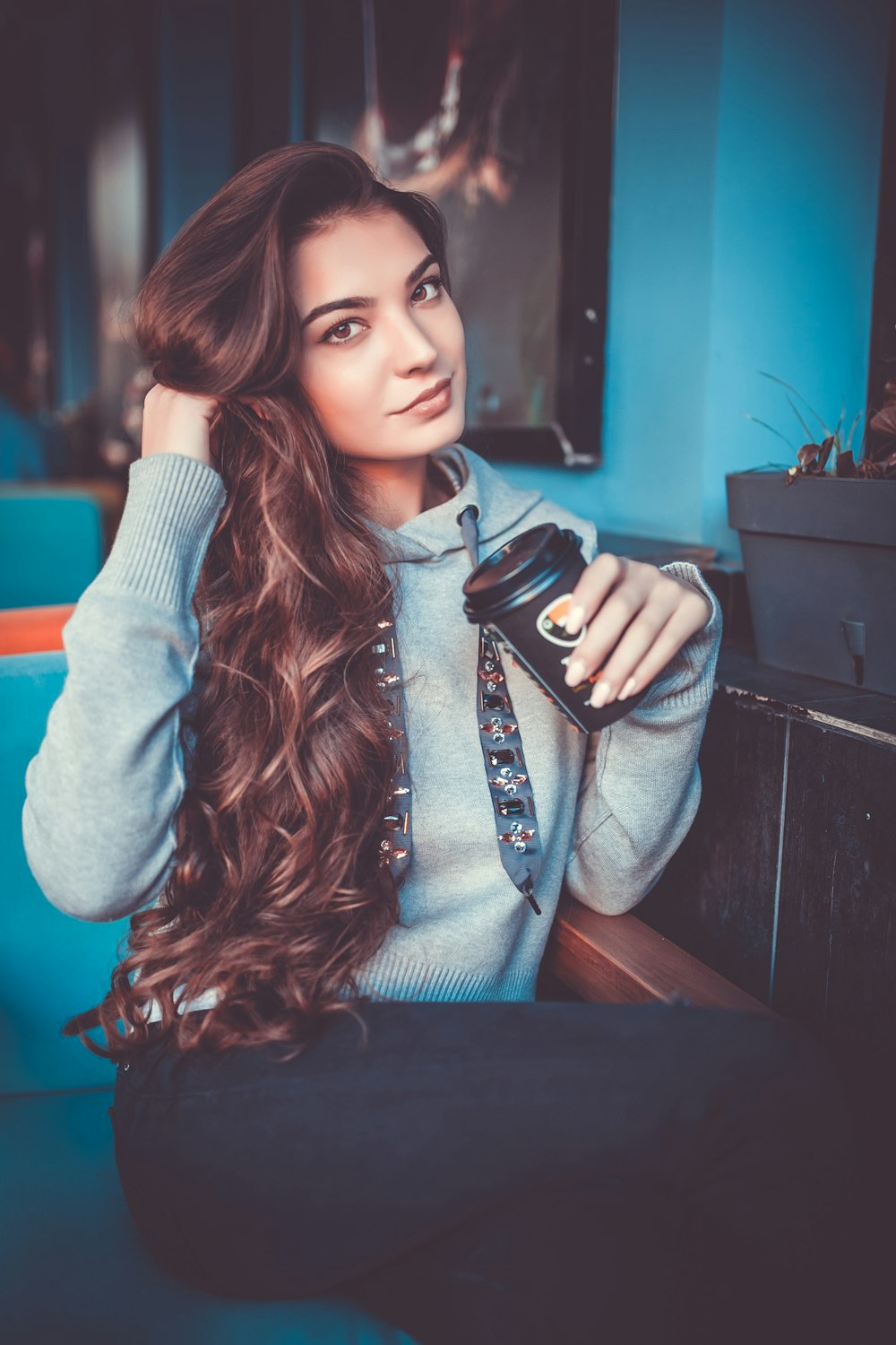 woman in gray pullover hoodie sitting on sofa