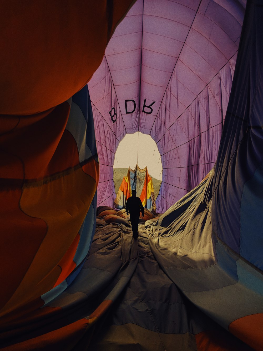 person walking inside purple tent tunnel
