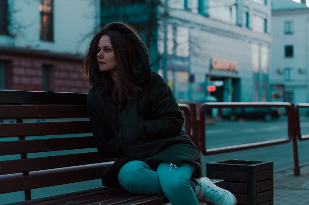 woman sitting on bench beside road