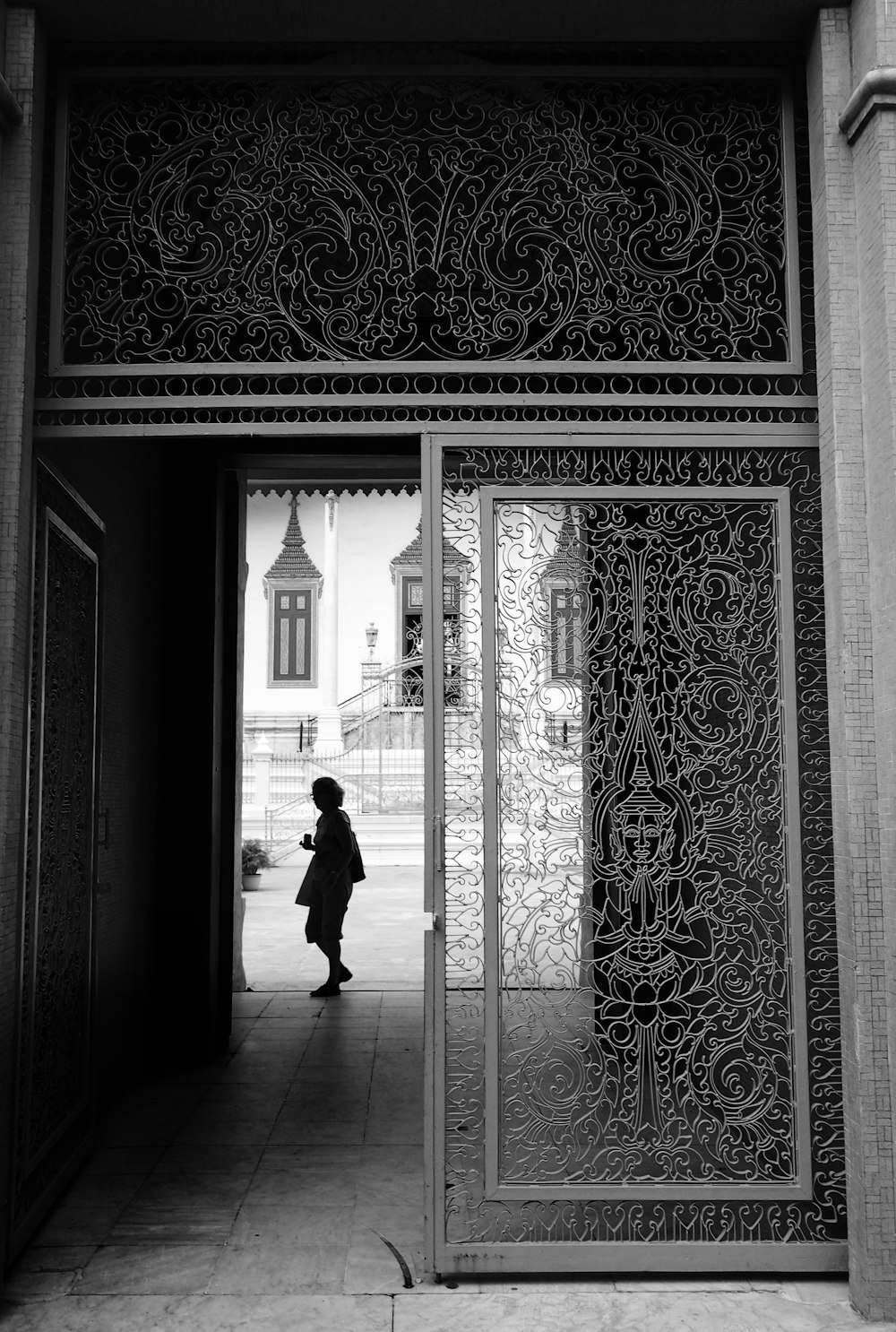 grayscale photography of person standing near hallway