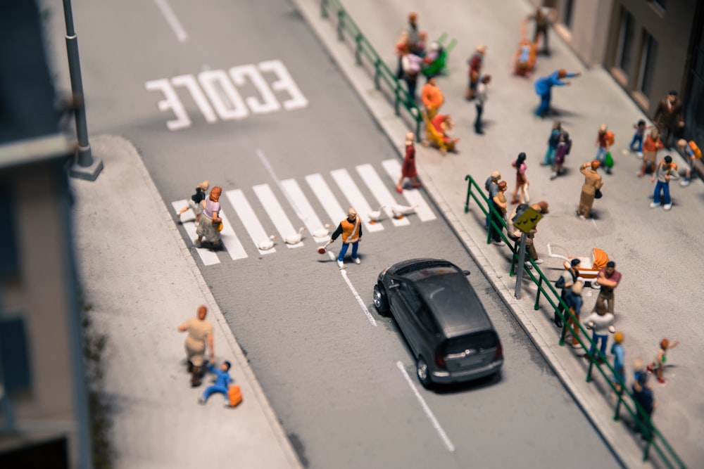 photo of people on sidewalk near building and car on pavement mini figures