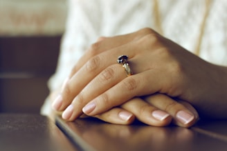 person wearing silver-colored ring with black gemstone and perfectly manicured hands