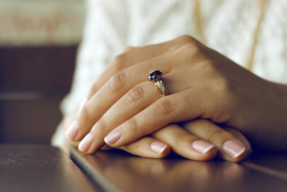 personne portant une bague argentée avec une pierre précieuse noire