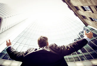 low-angle photography of man in the middle of buidligns