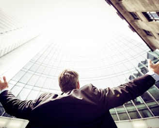 low-angle photography of man in the middle of buidligns